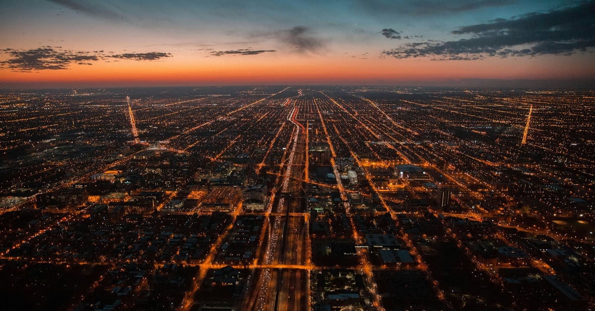 Aerial view of a large city at night. Streets are lit up by thousands of street lights.