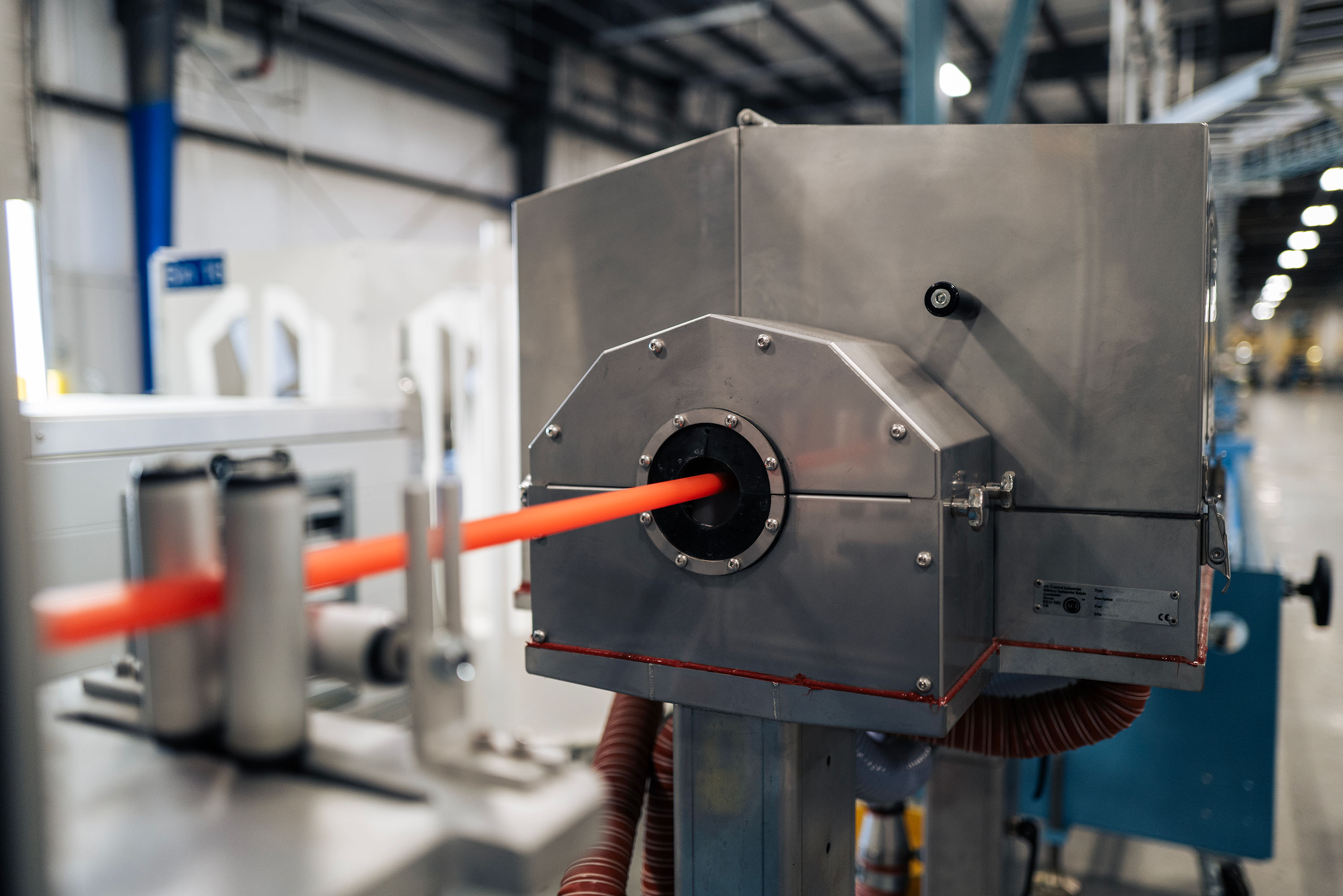 A close-up of an industrial machine that produces a micro duct. The machine has a metallic exterior.