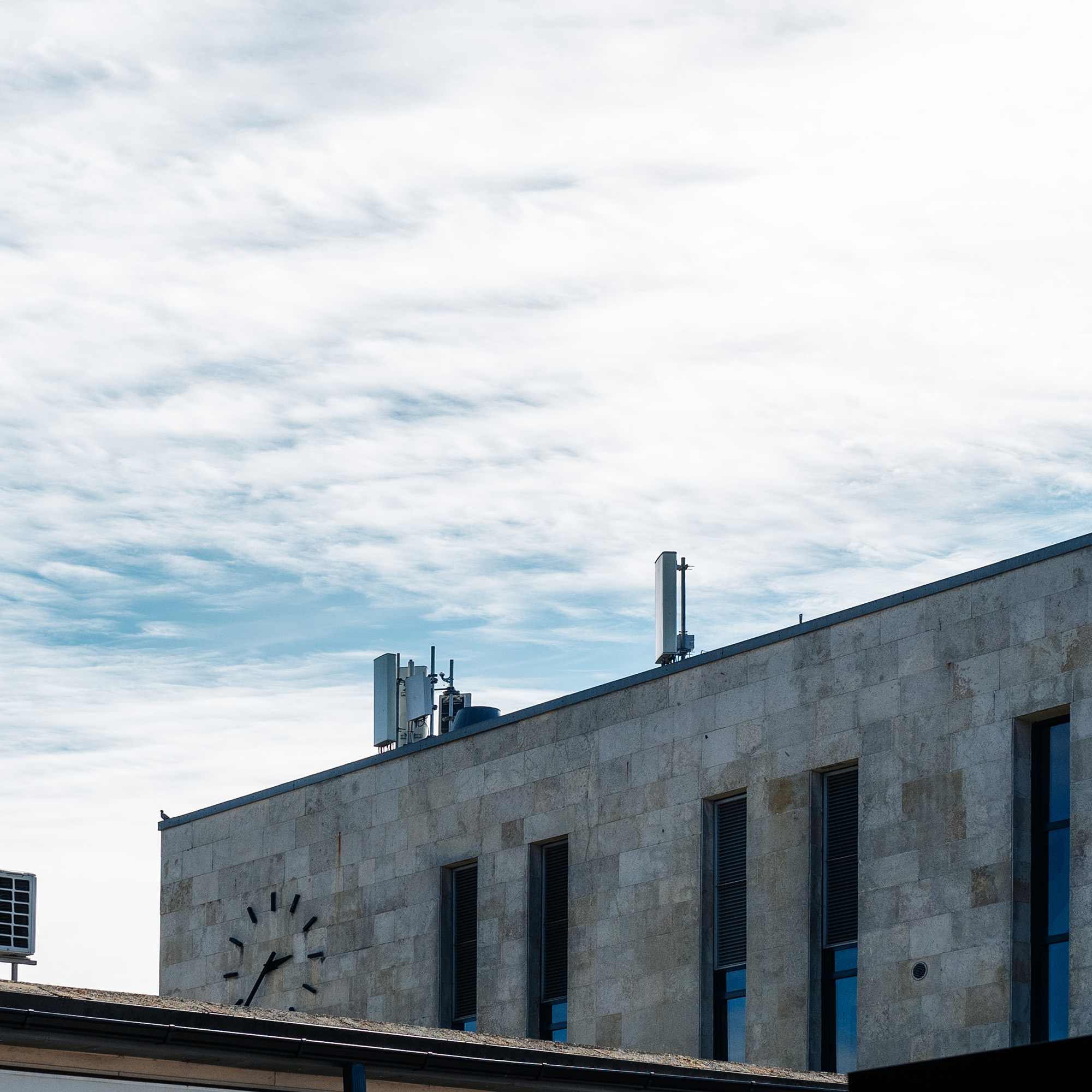 5G antenna on a rooftop under a blue sky.