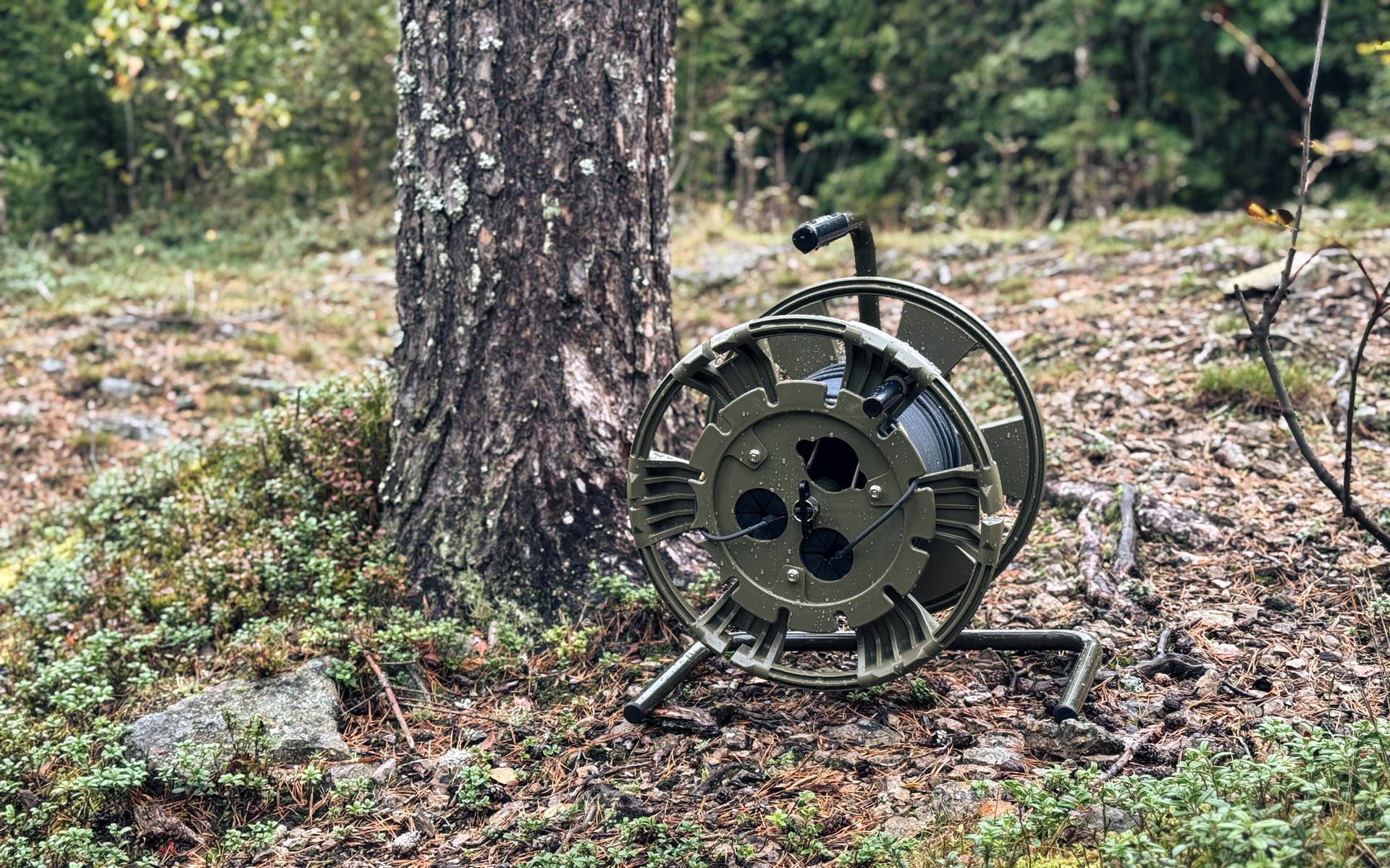 Hexatronic FieldLink field-deployable fiber optic system in a forest setting next to a tree.