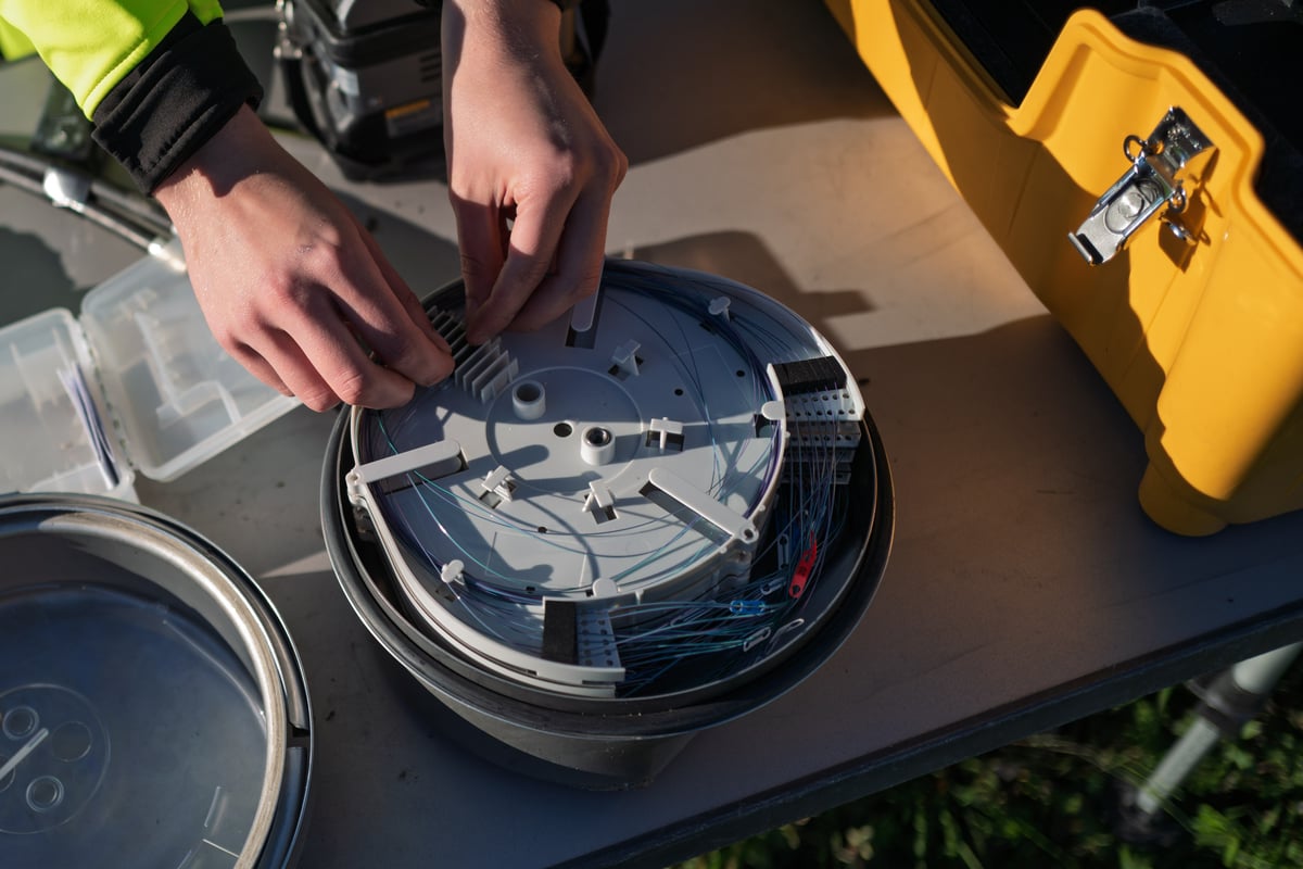 Fiber technician installing fiber cable in a dome closure.