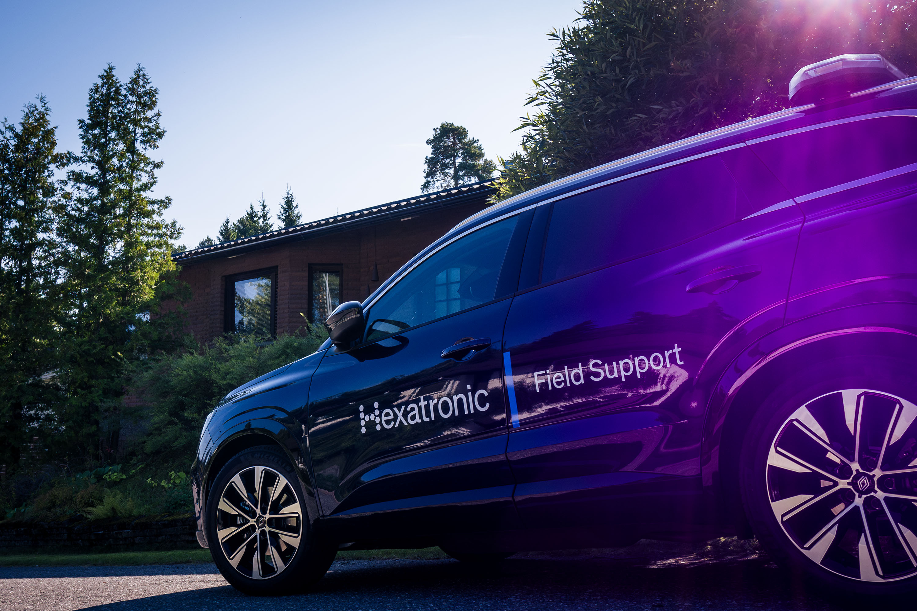 Hexatronic field support branded car parked on a street.