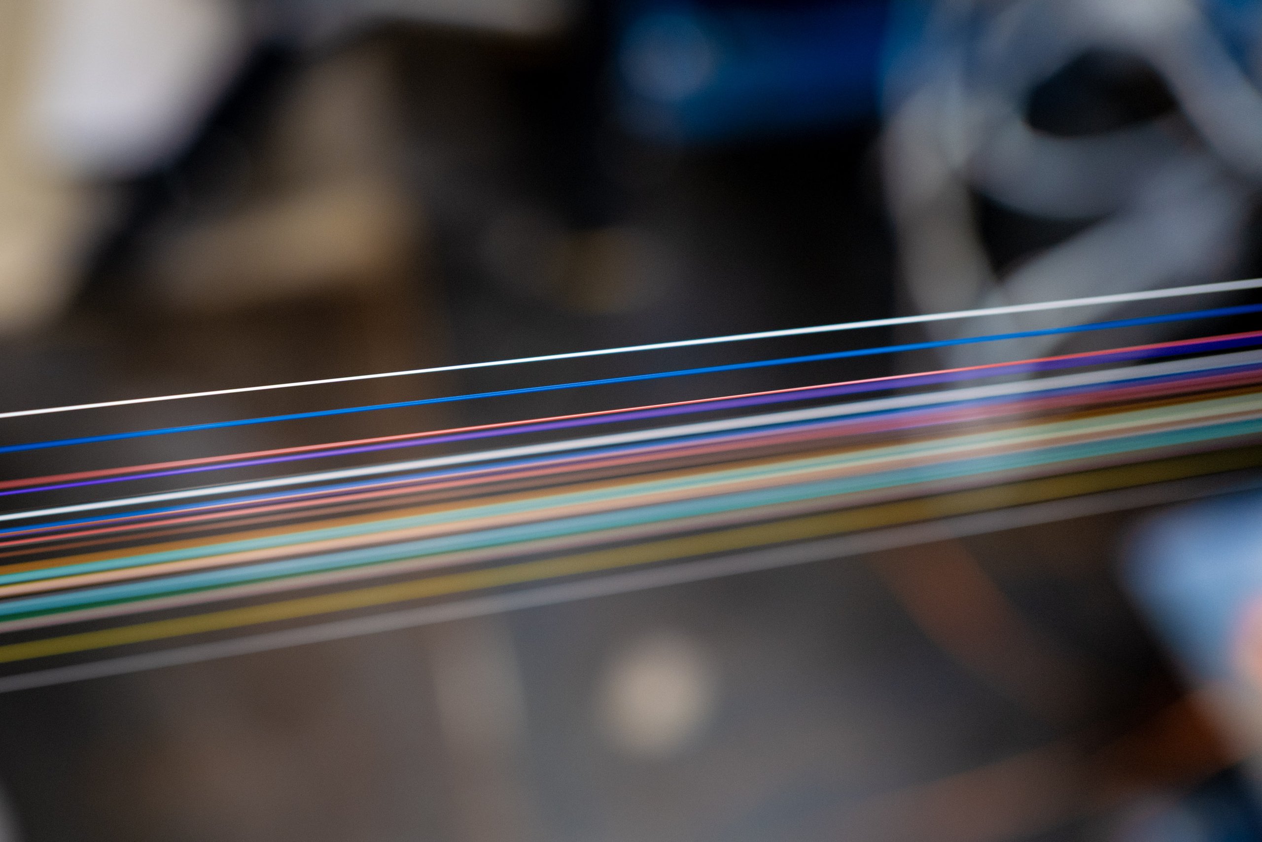 Colorful multiple fiber optic cables passing through the assembly line.