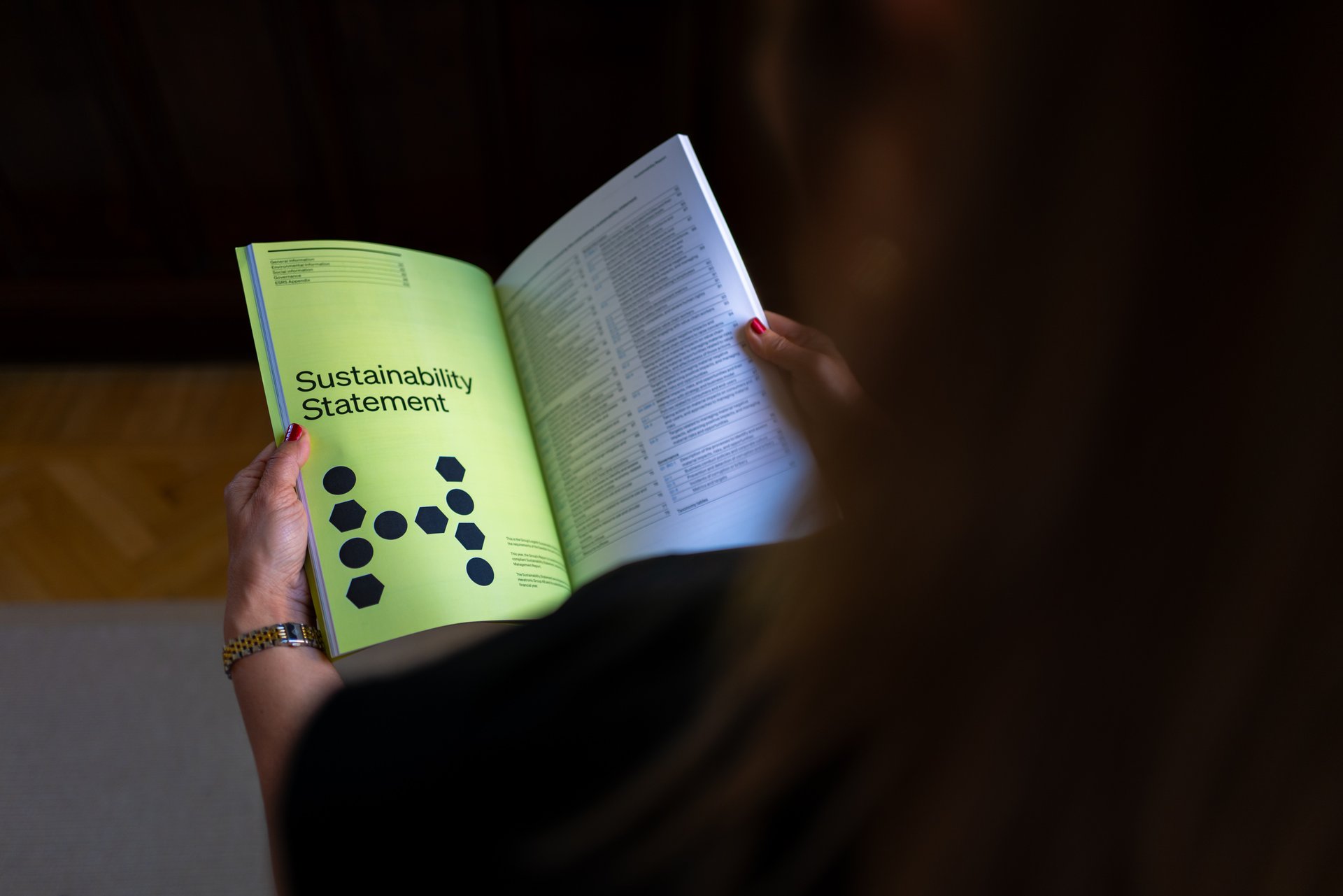 Person reading the Hexatronic Sustainability Statement 2025. 